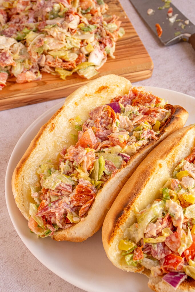 A pair of Chopped Italian Sandwiches on a white plate.