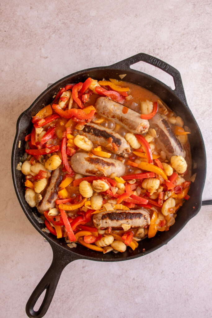 Cooking gnocchi with sausages and peppers.