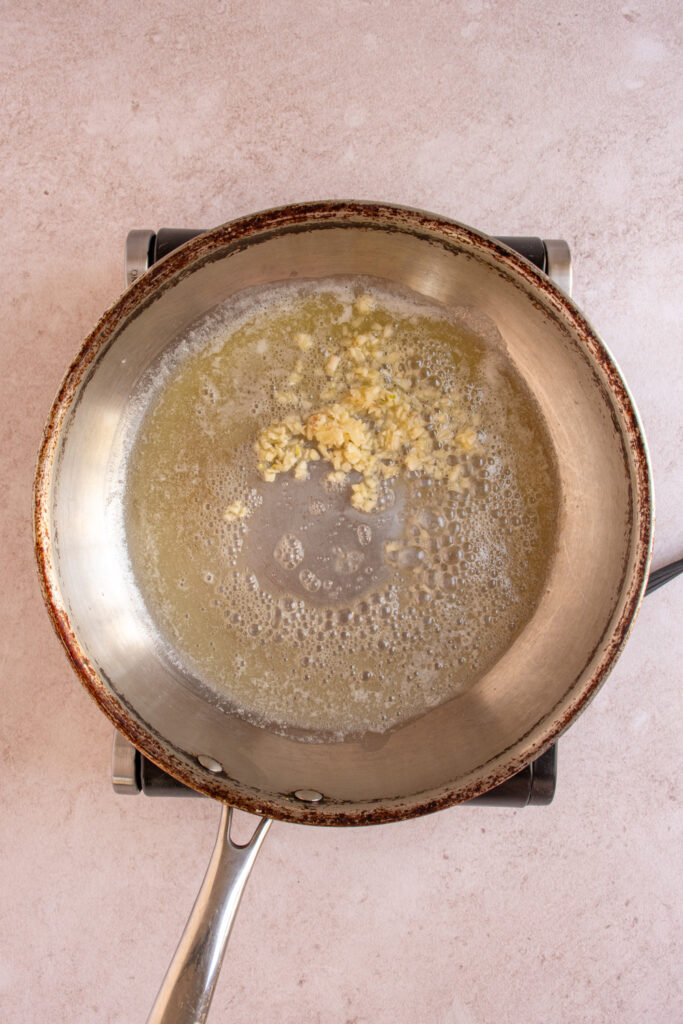 Skillet with melted butter and minced garlic.