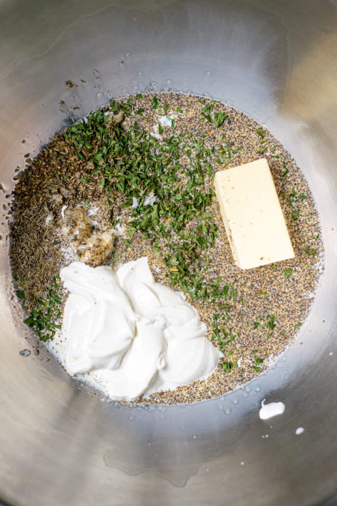 bowl full of dairy, herbs, and garlic for seasoning and finishing off the mashed potatoes