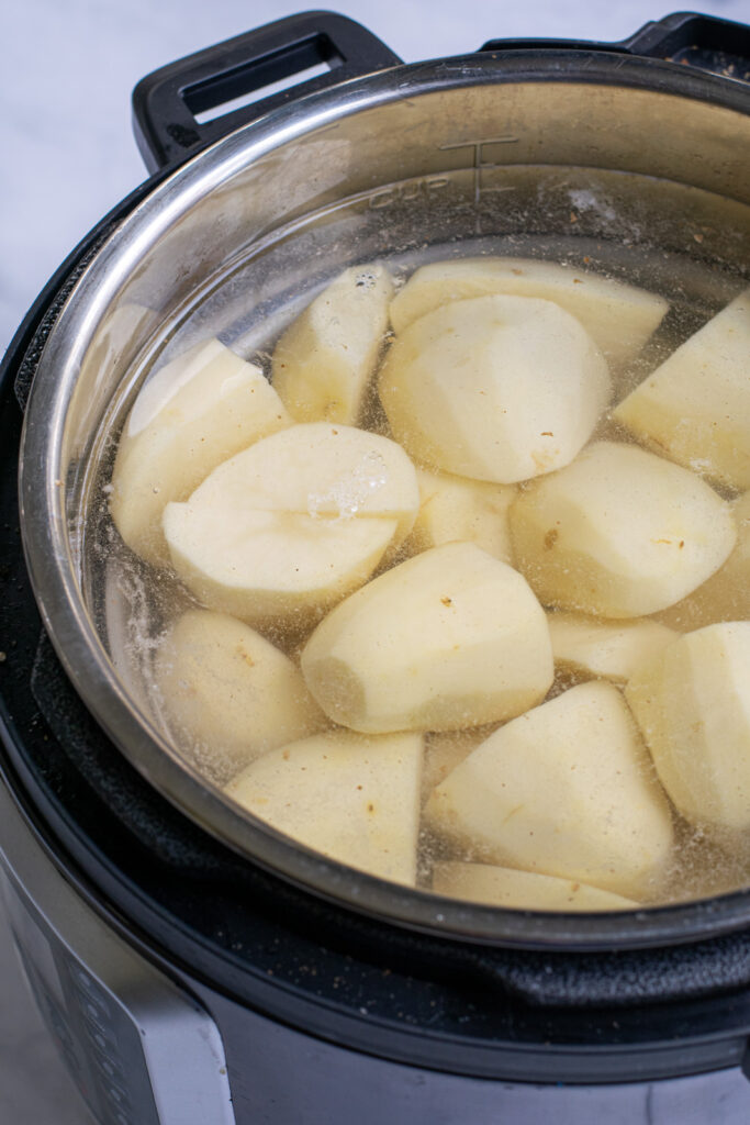 pressure cooker full of potatoes and water