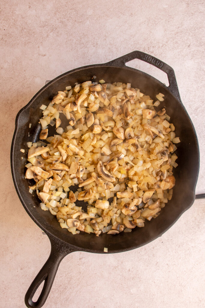 Cooked mushrooms and diced onion in a large skillet.