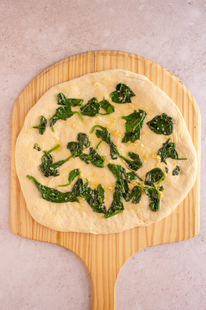 Garlic Butter with sautéed spinach on top of pizza dough.
