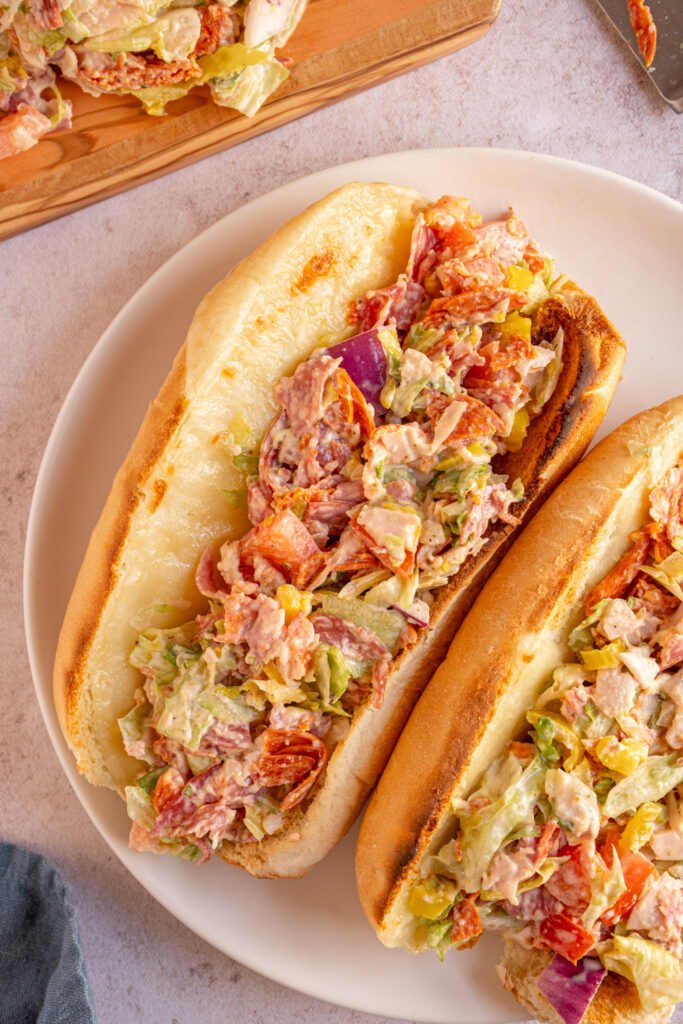 Overhead view of viral chopped italian sandwich on a white plate.