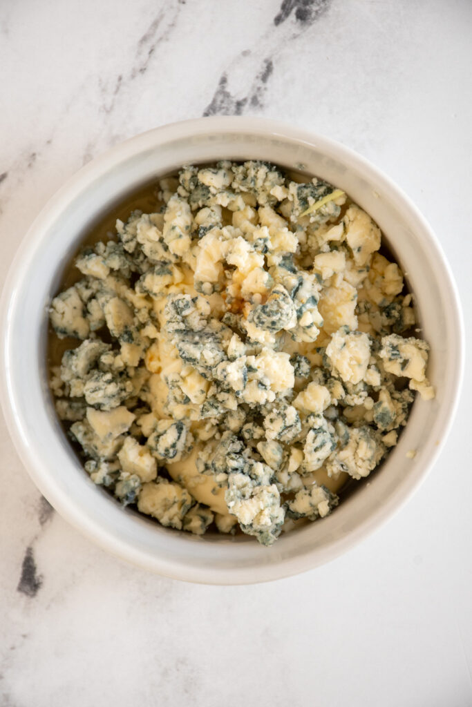A small bowl filled with crumbled blue cheese.