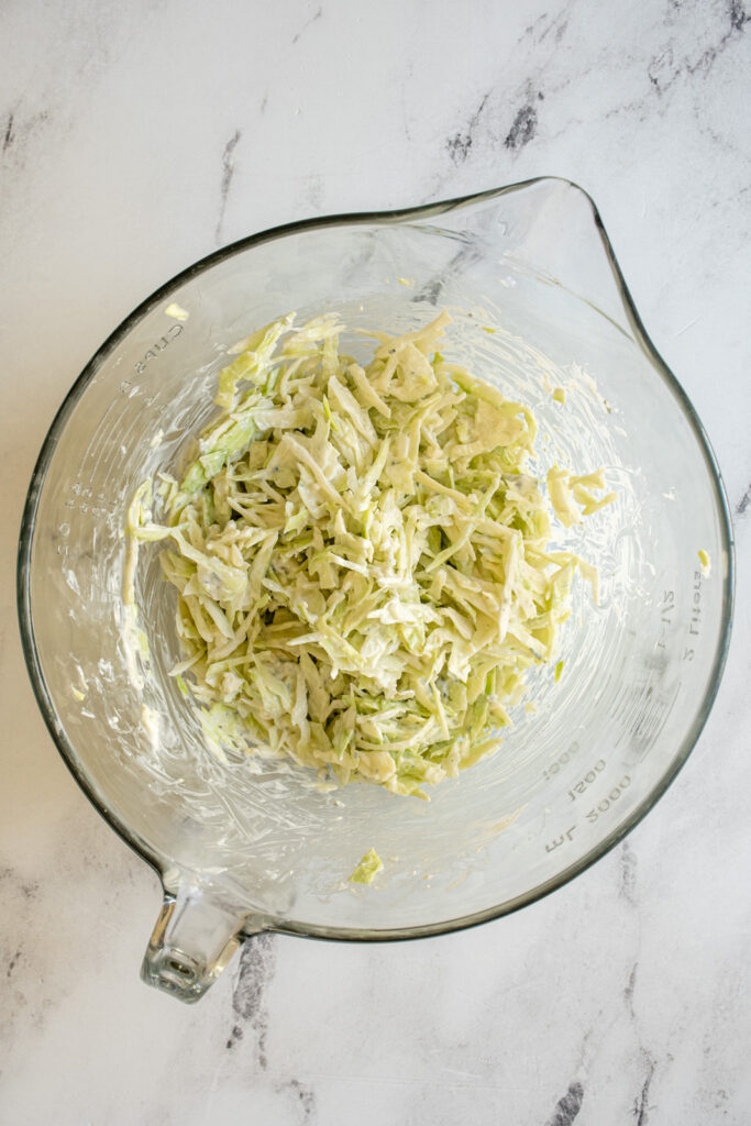 A glass bowl filled with blue cheese coleslaw.