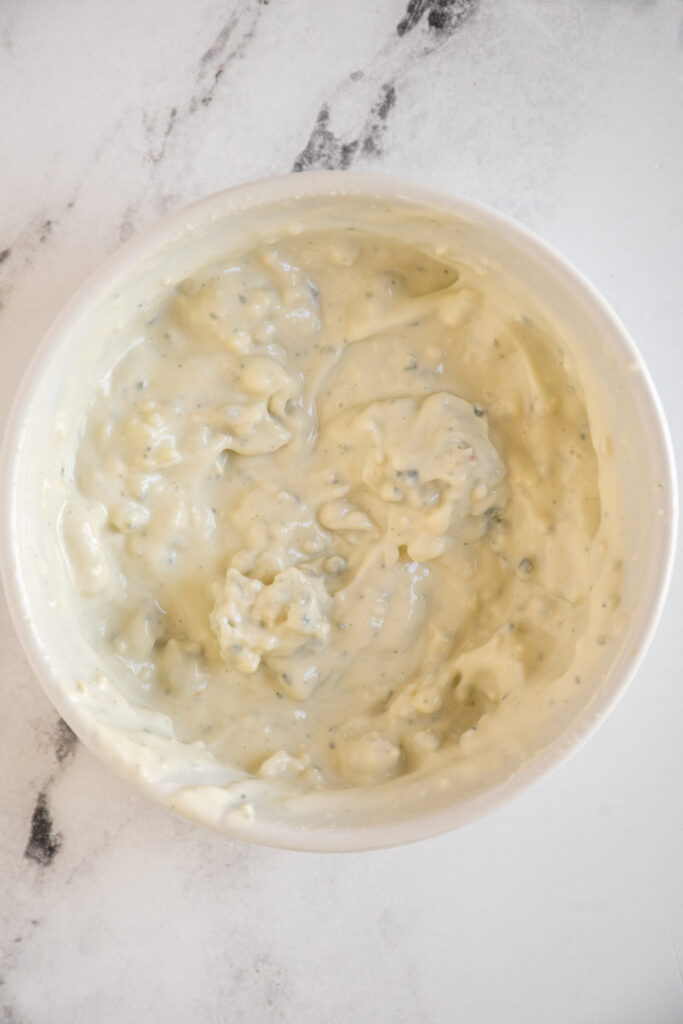 Blue cheese coleslaw dressing in a small white bowl.