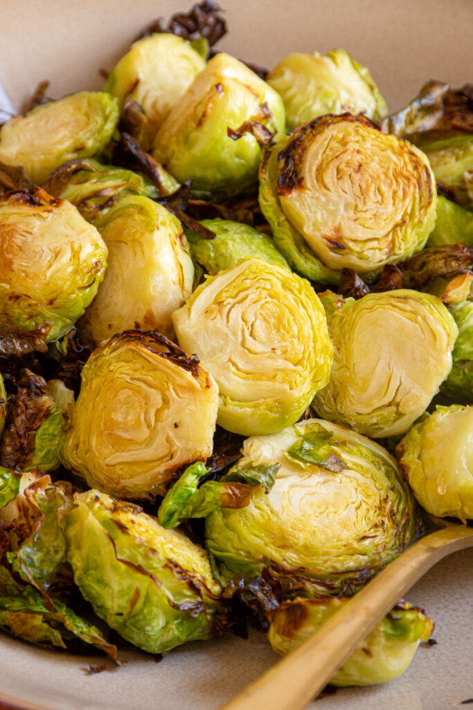 Close up of air fryer brussel sprouts in a brown serving bowl.