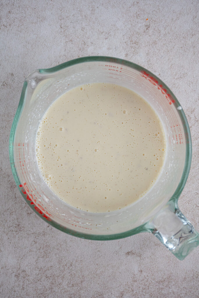 Coleslaw dressing in a large glass measuring cup.