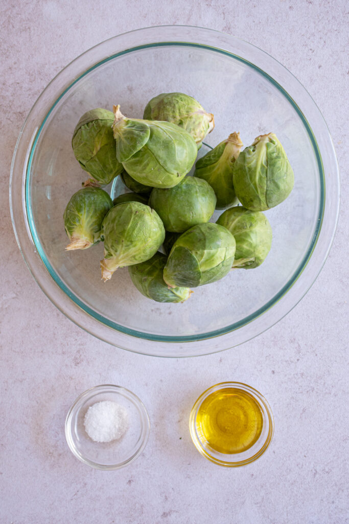 Ingredients needed to make air fryer brussel sprouts laid out on a tabletop.
