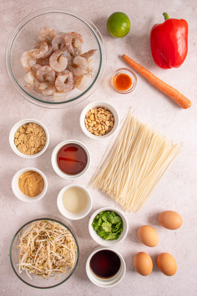 Ingredients for making shrimp pad thai laid out on a tabletop.