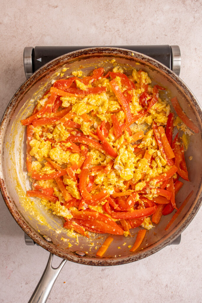 The freshly scrambled eggs mixed with the red pepper and carrots.