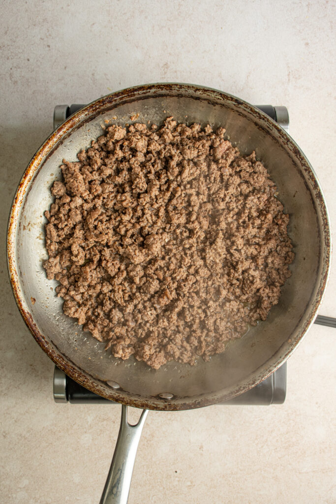A large skillet with browned ground beef.