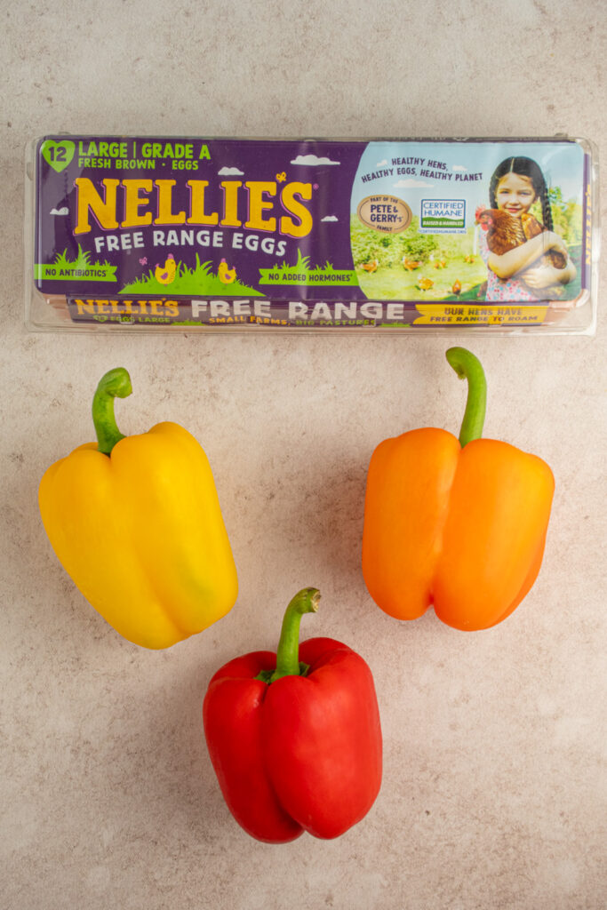 Ingredients needed to make bell pepper eggs laid out on a tabletop.