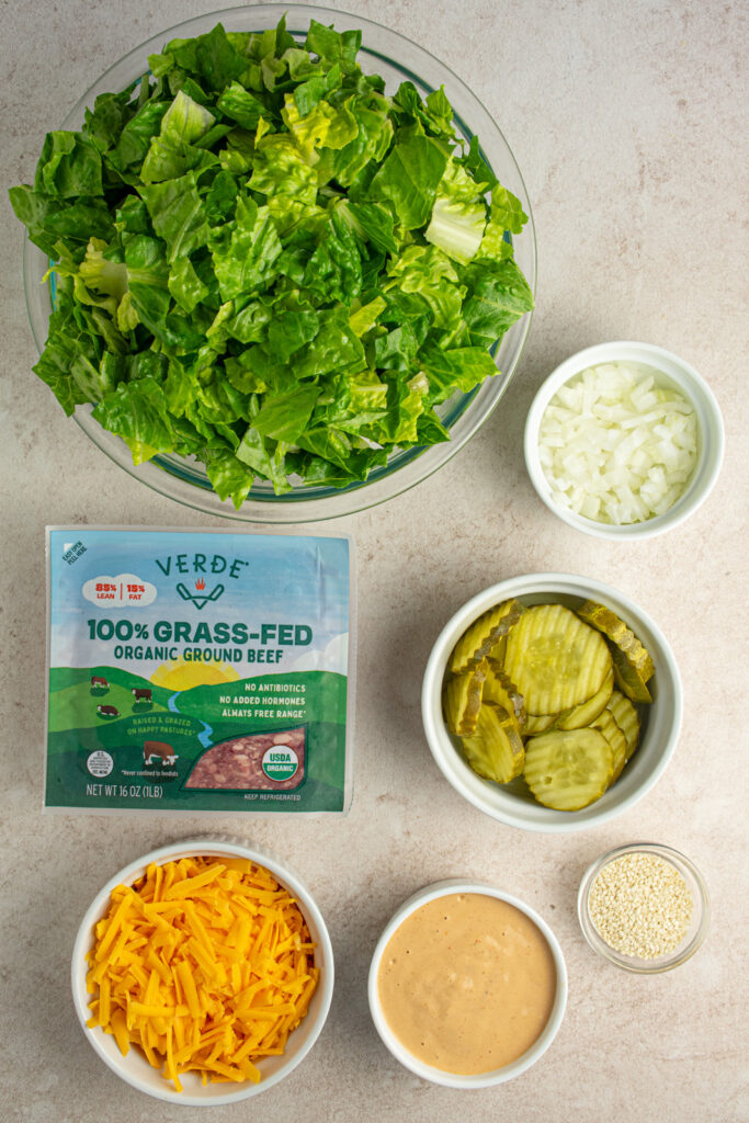 Ingredients to make big mac salad laid out on a tabletop.