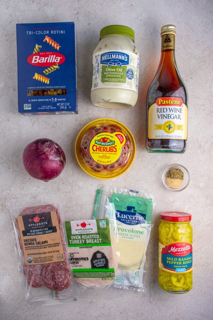 Ingredients needed for making grinder pasta salad laid out on a tabletop.