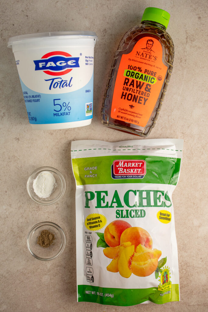 Ingredients needed to make peach yogurt popsicles on a tabletop.