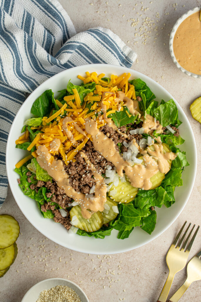 Overhead view of a white bowl with big mac salad with special sauce.
