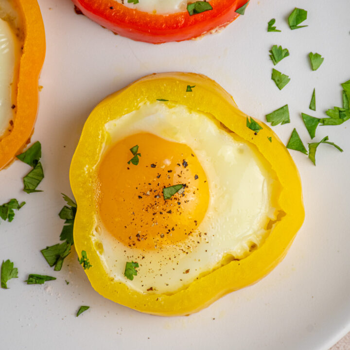 Overhead view of a cooked egg inside a yellow bell pepper ring.
