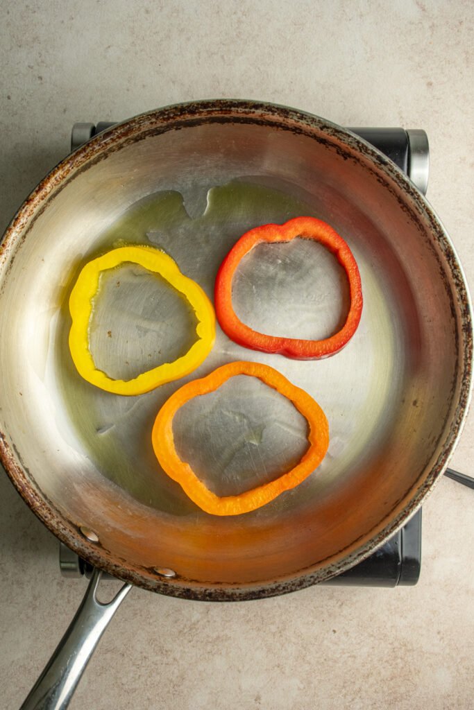 Bell pepper rings in a skillet.