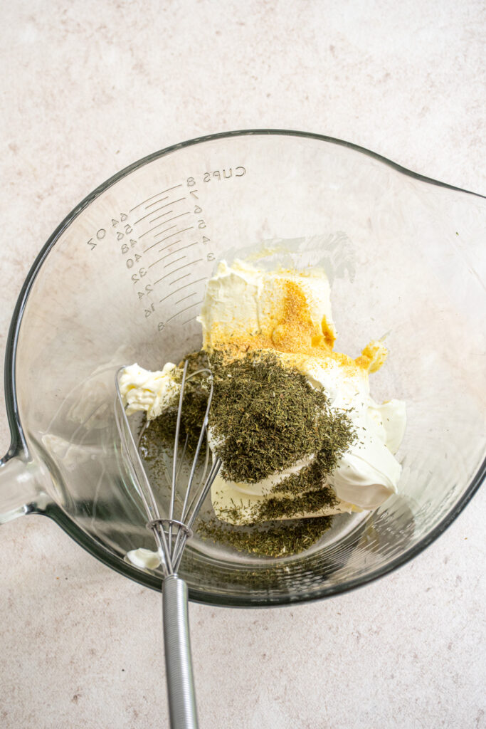 Dill weed and garlic powder added to the cream cheese and sour cream to make the dill dip for the topping.