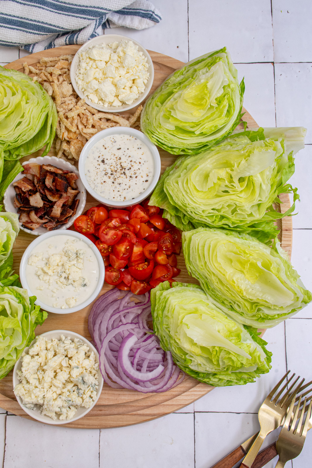 A large wood board filled with the toppings for making a wedge salad board.