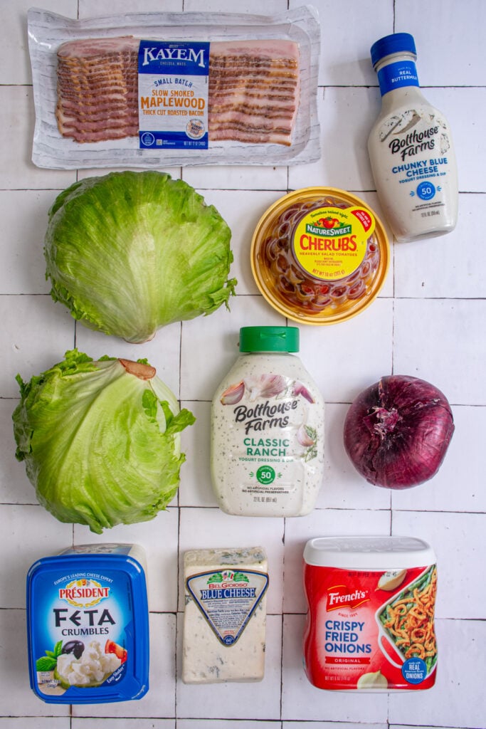 Ingredients for making a wedge salad board laid out on a tabletop.