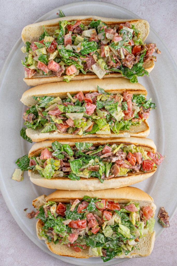 Overhead view of a serving platter with four chopped BLT sandwiches.