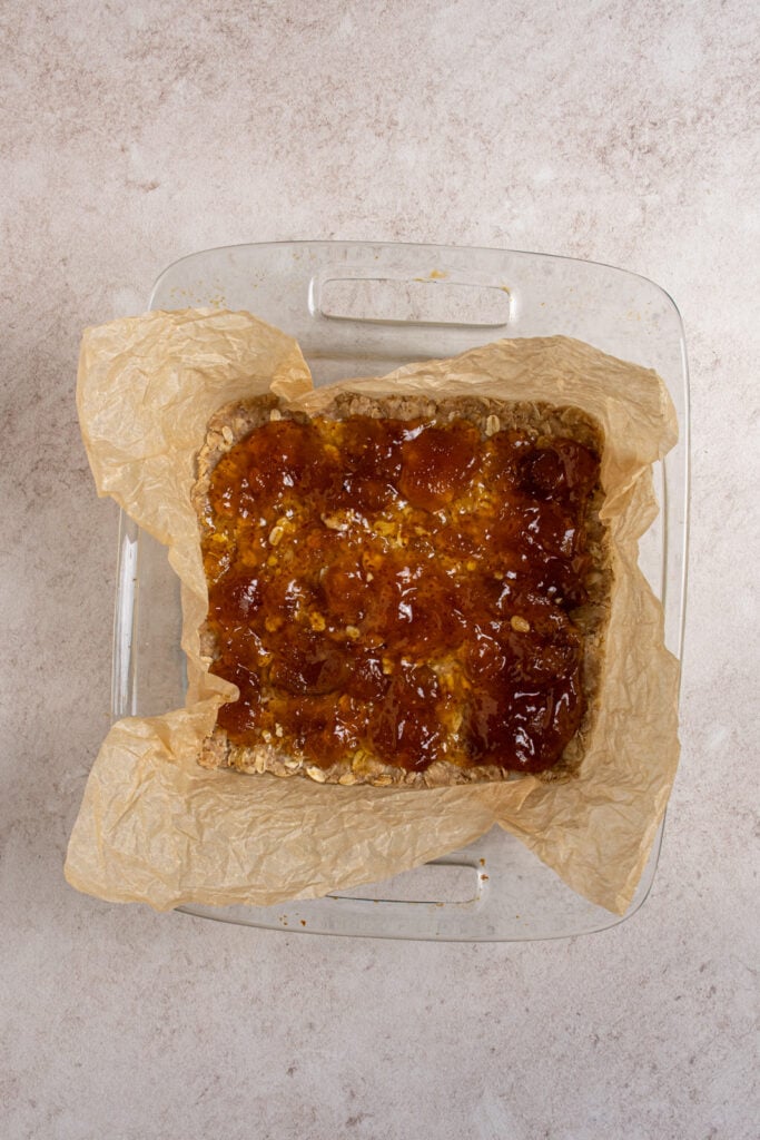 Adding fig jam to the oatmeal crust.