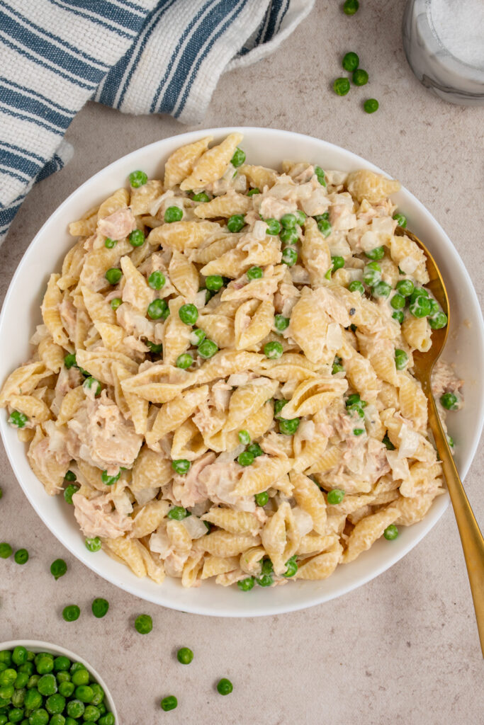 An overhead view of a white serving bowl with tuna pasta salad.