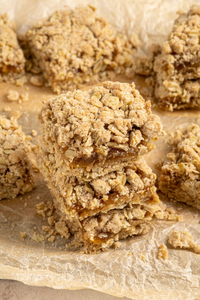 Looking down at three stacked fig oat bars on a piece of parchment paper.