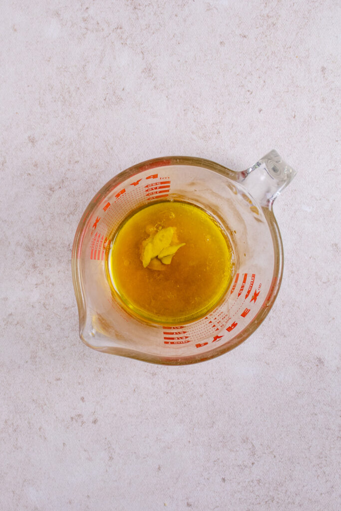 Ingredients for the salad dressing in a glass measuring cup.