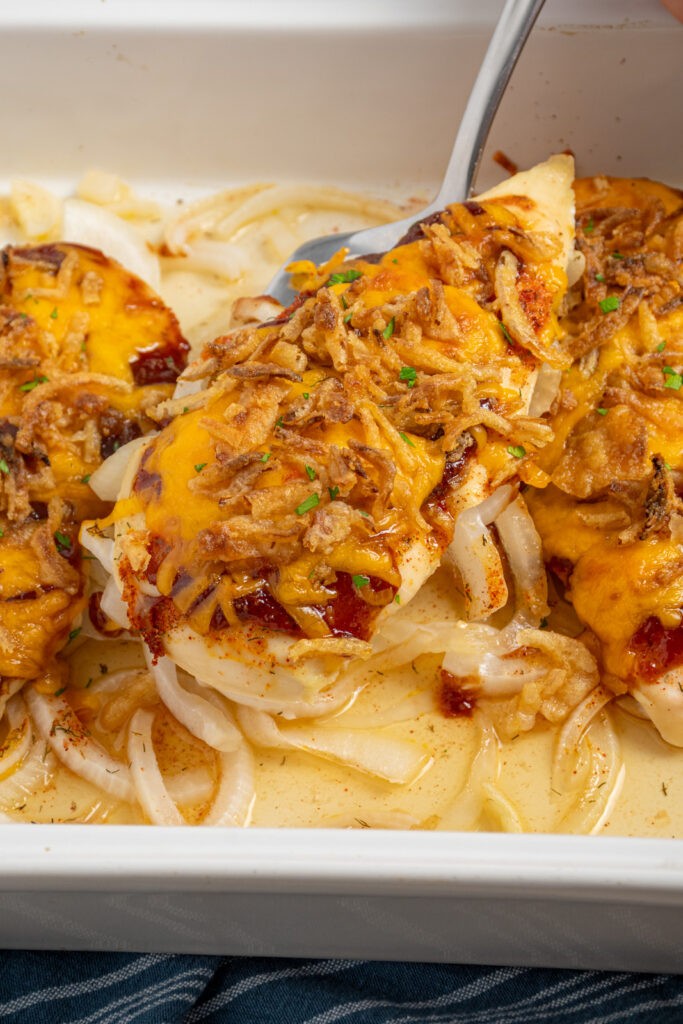 A cheesy barbecue chicken breast on a spatula.