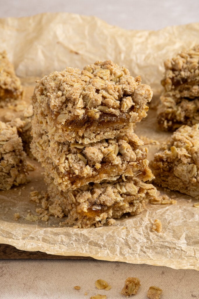 A stack of three fig oat bars on a piece of parchment paper.