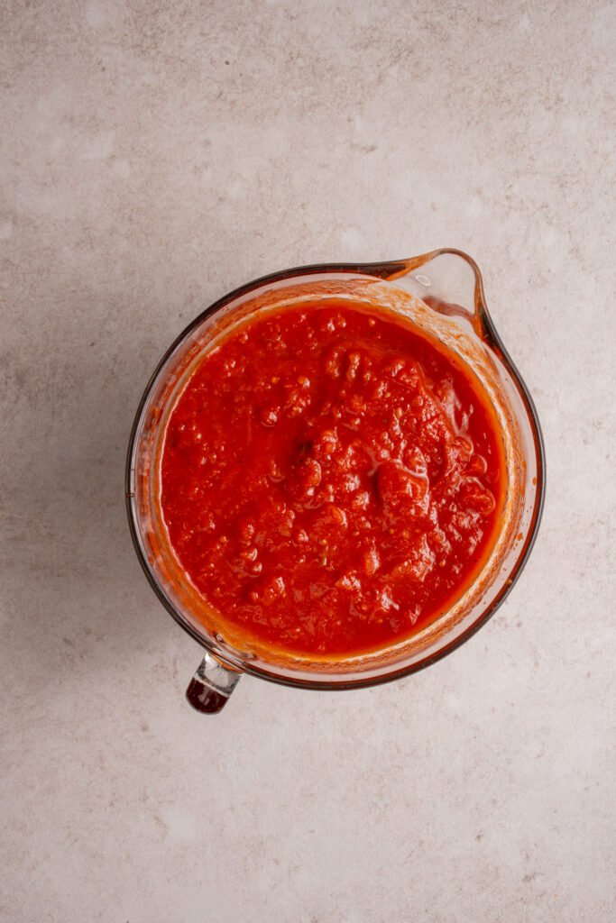 A large glass bowl holding all the tomatoes and sauce mixed together.