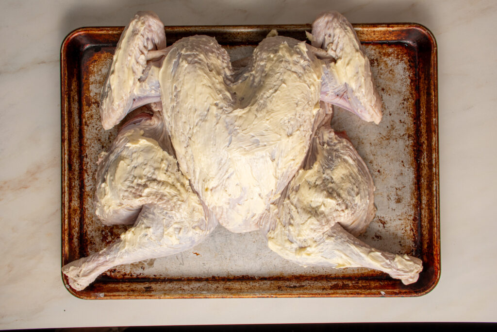 Butter slathered on a spatchcocked turkey.