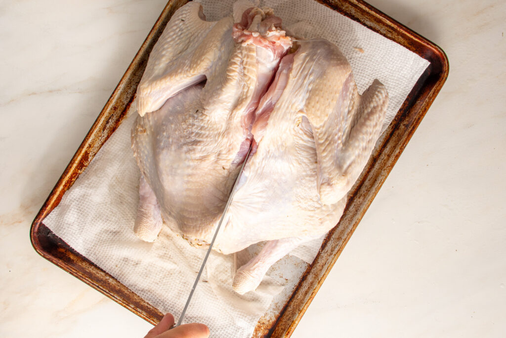 Cutting the next to the back bone of a turkey.