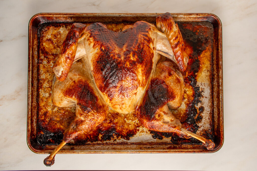A roasted spatchcocked turkey on a sheet platter.