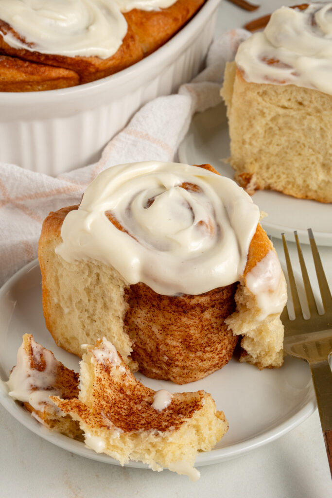 A fluffy cinnamon roll opened up to show the cinnamon insides.