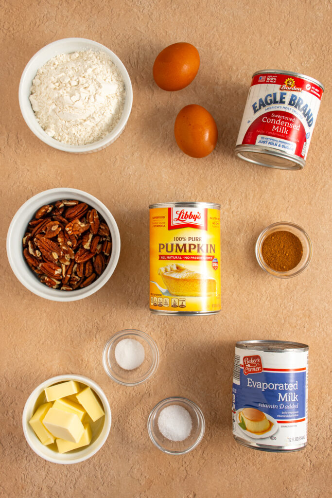 Ingredients needed to make pumpkin pie with pecan crust laid out on a tabletop.