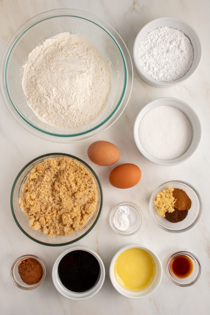 Ingredients to make gingerbread crinkle cookies laid out on a tabletop.