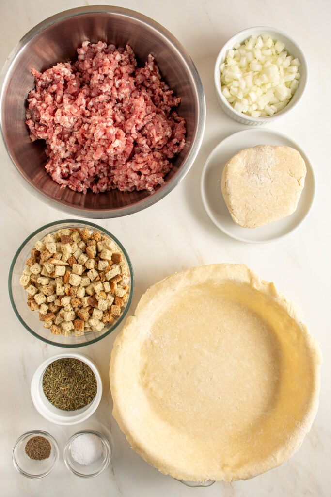 Ingredients needed to make tourtière recipe laid out on a tabletop.