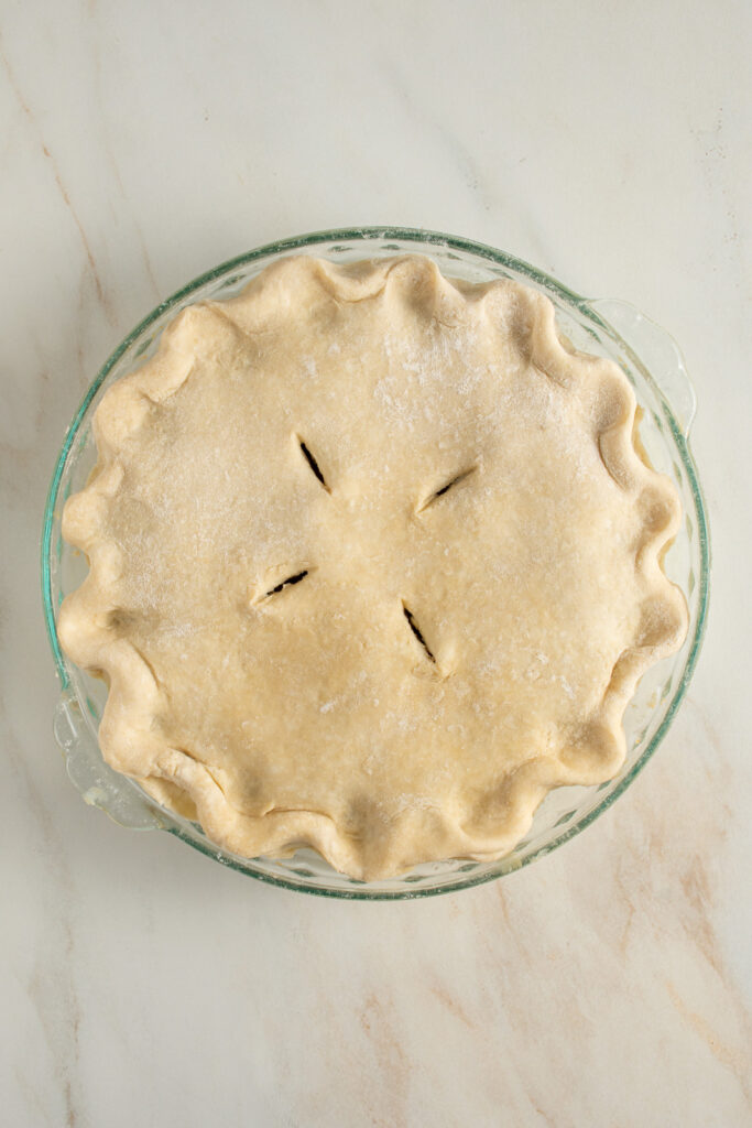 An uncooked pork pie on a table top.