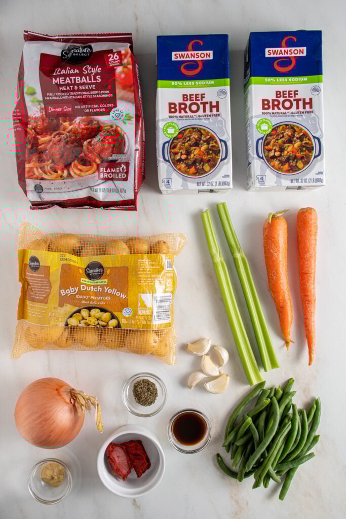 Ingredients needed to make crockpot meatball stew laid out on a tabletop.