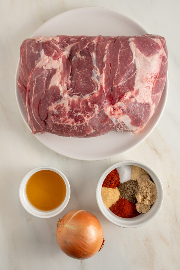 Ingredients needed to make crockpot pulled pork laid out on a tabletop.