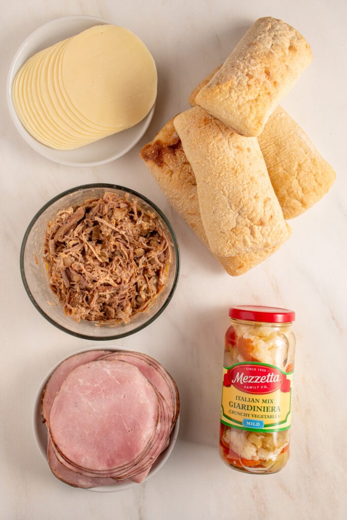 Ingredients to make Italian Pulled Pork Sandwich laid out on a tabletop.