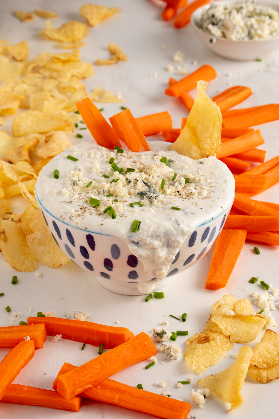 A bowl with Blue Cheese Dip garnished with blue cheese.