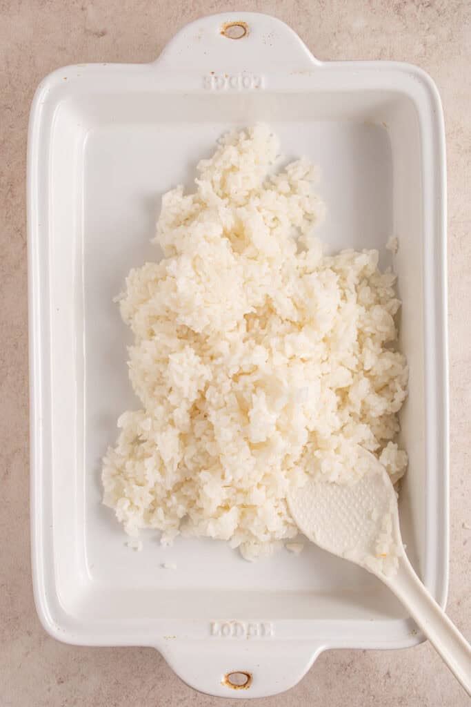 Adding rice to a casserole dish.