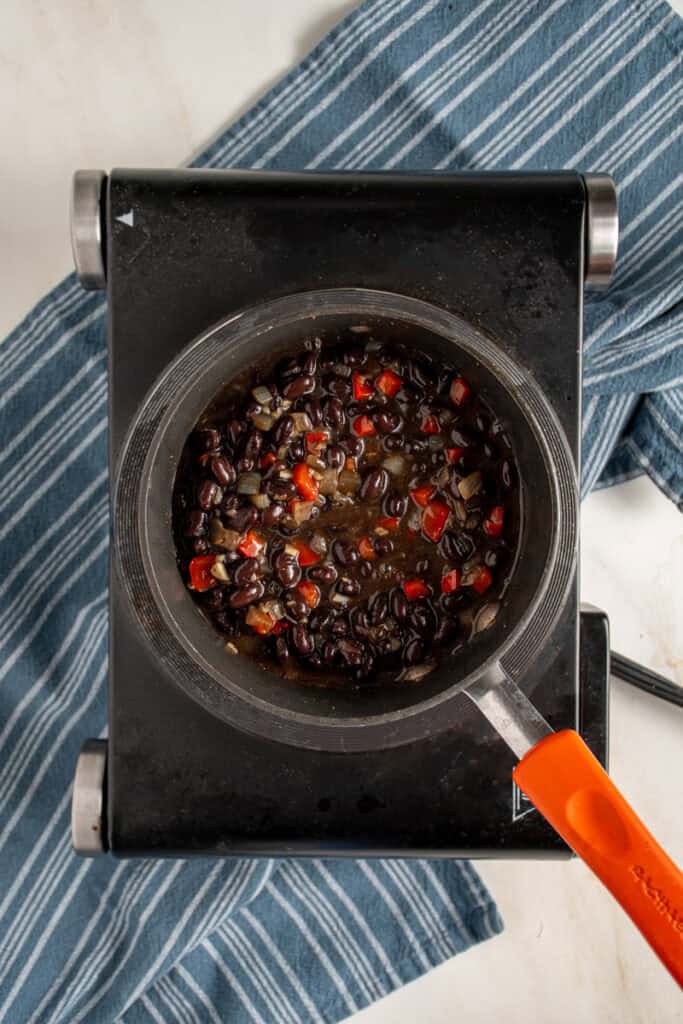 Seasoned black beans in a small pot.