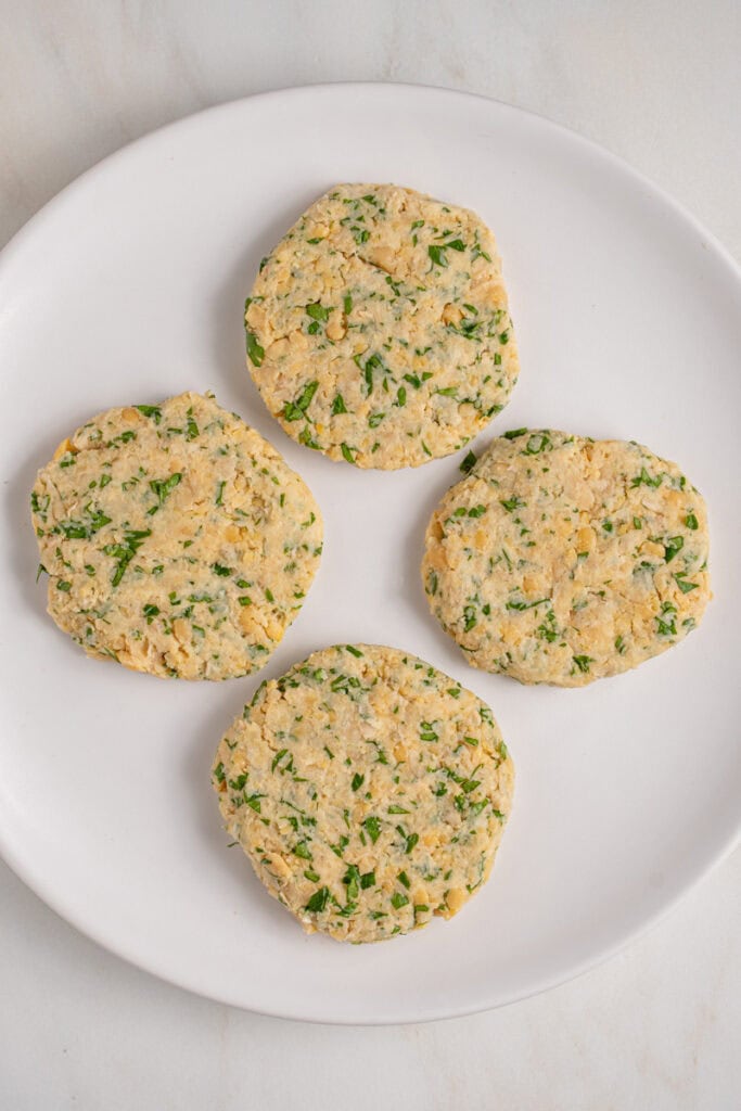 Raw chickpea fritters patties on a plate.